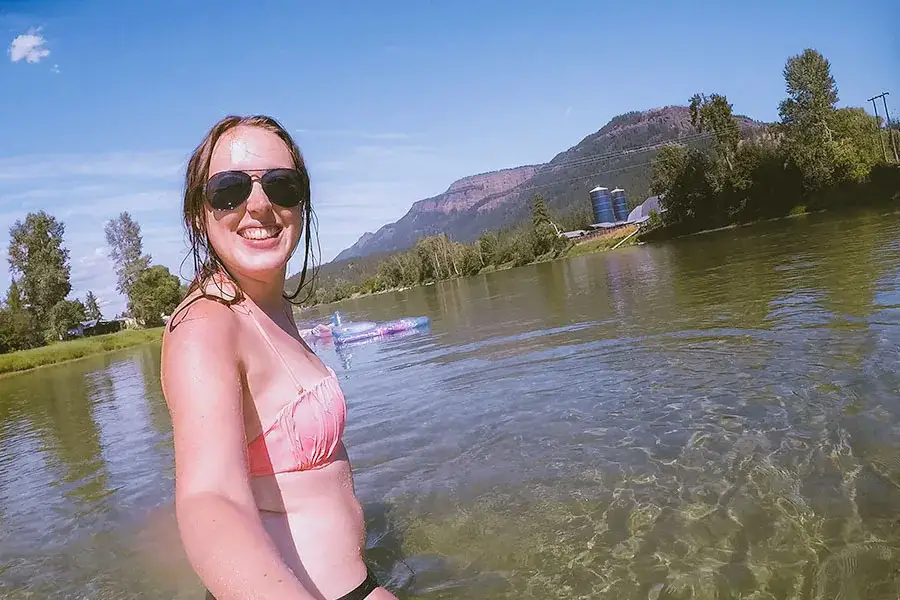 Selfie of a woman walking in the Enderby River during the summer.