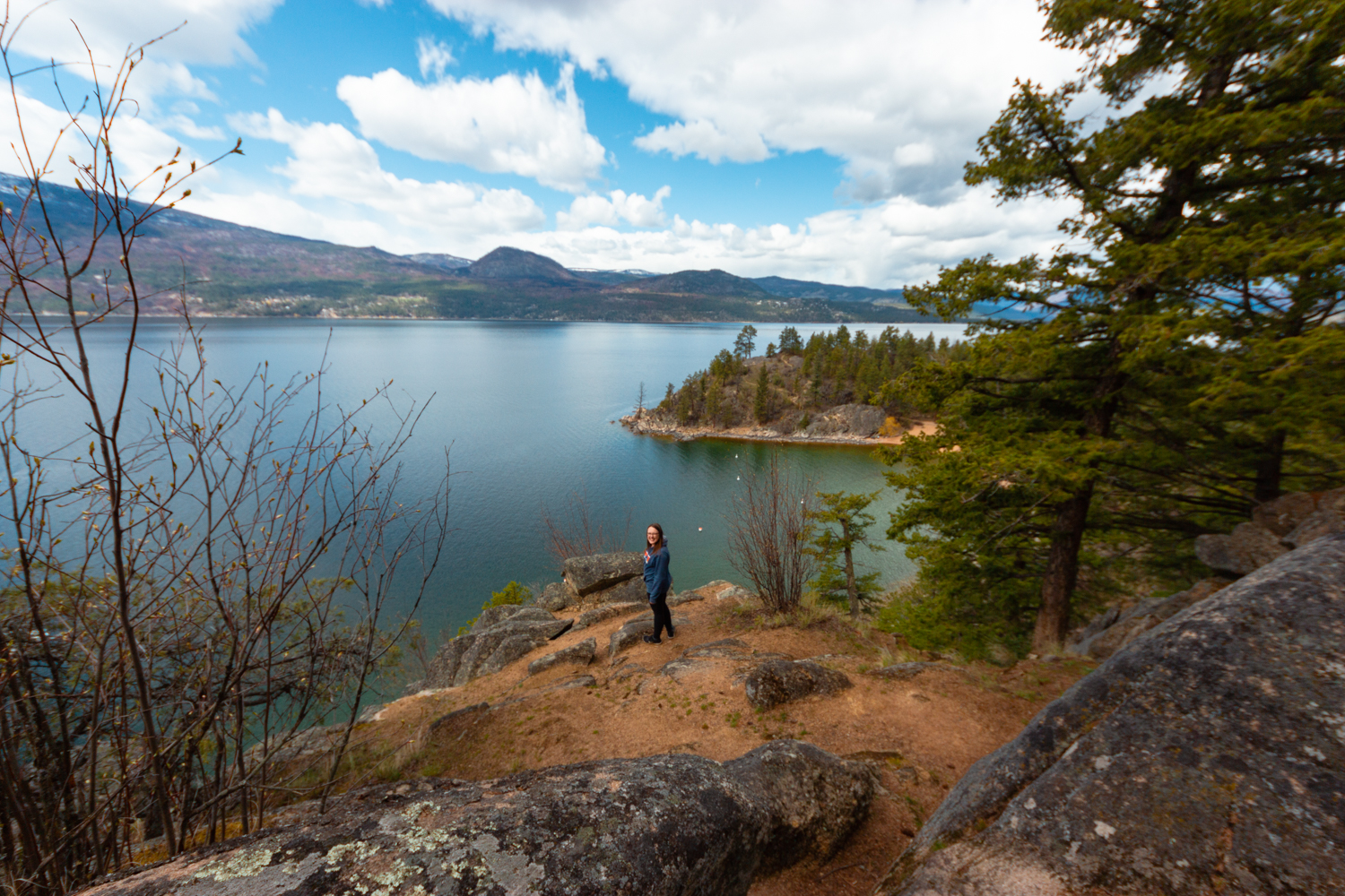 Woman stands on a bluff above the lake at Ellison