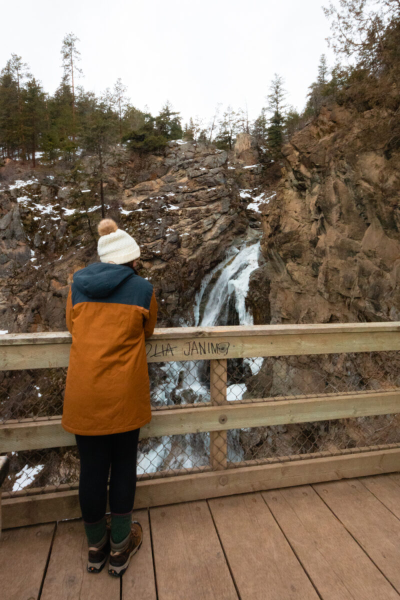 Woman looks at a frozen waterfall