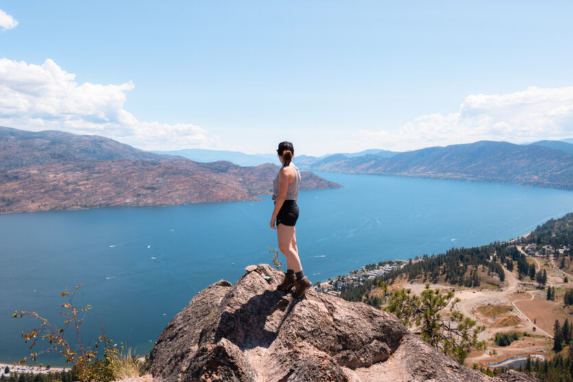 Women standing on a rock at the top of Pincushion Mountain overlooking Okanagan Lake.