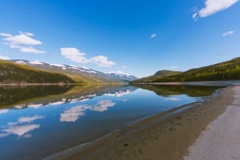 Sandy beach at Blanket Creek Provincial Park. Mirror like water on Arrow Lake.