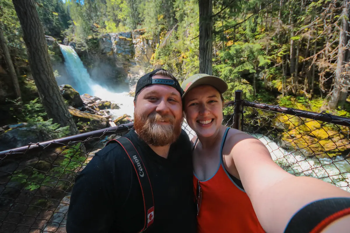 Selfie of a man and woman in front of Sutherland Falls in Revelstoke, BC.