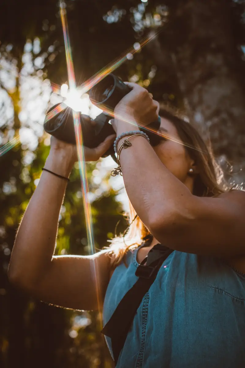 Woman looks through binoculars in the forest