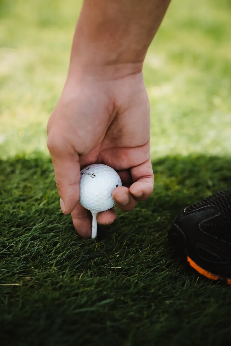 Hand putting down a golf ball