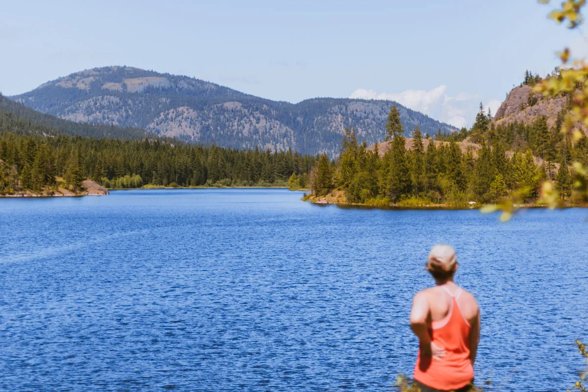 Woman in red stands on the shores of the Rose Valley Reservoir