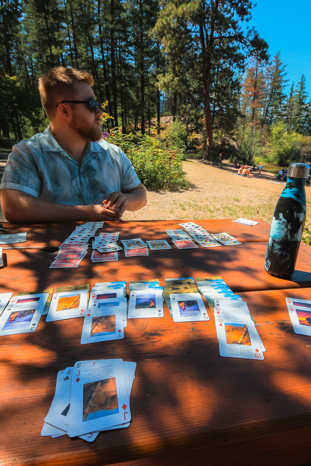 Man plays cards at Ellison's day-use beach