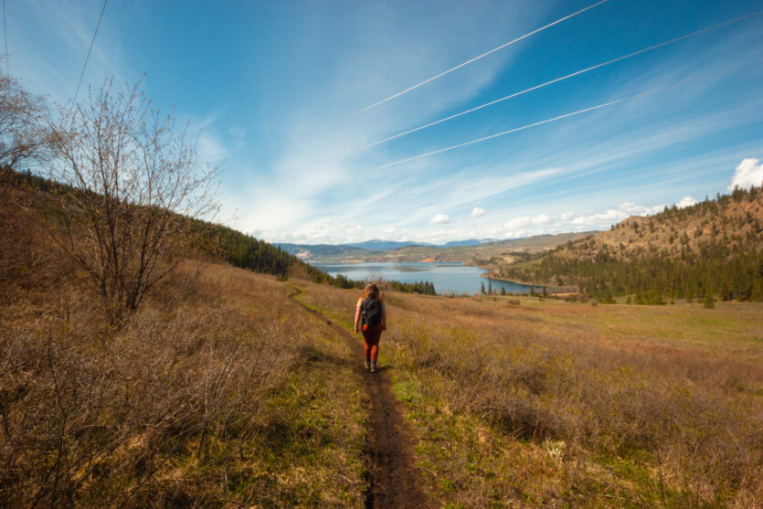Women hikes on a trail in Kal Lake on a sunny day