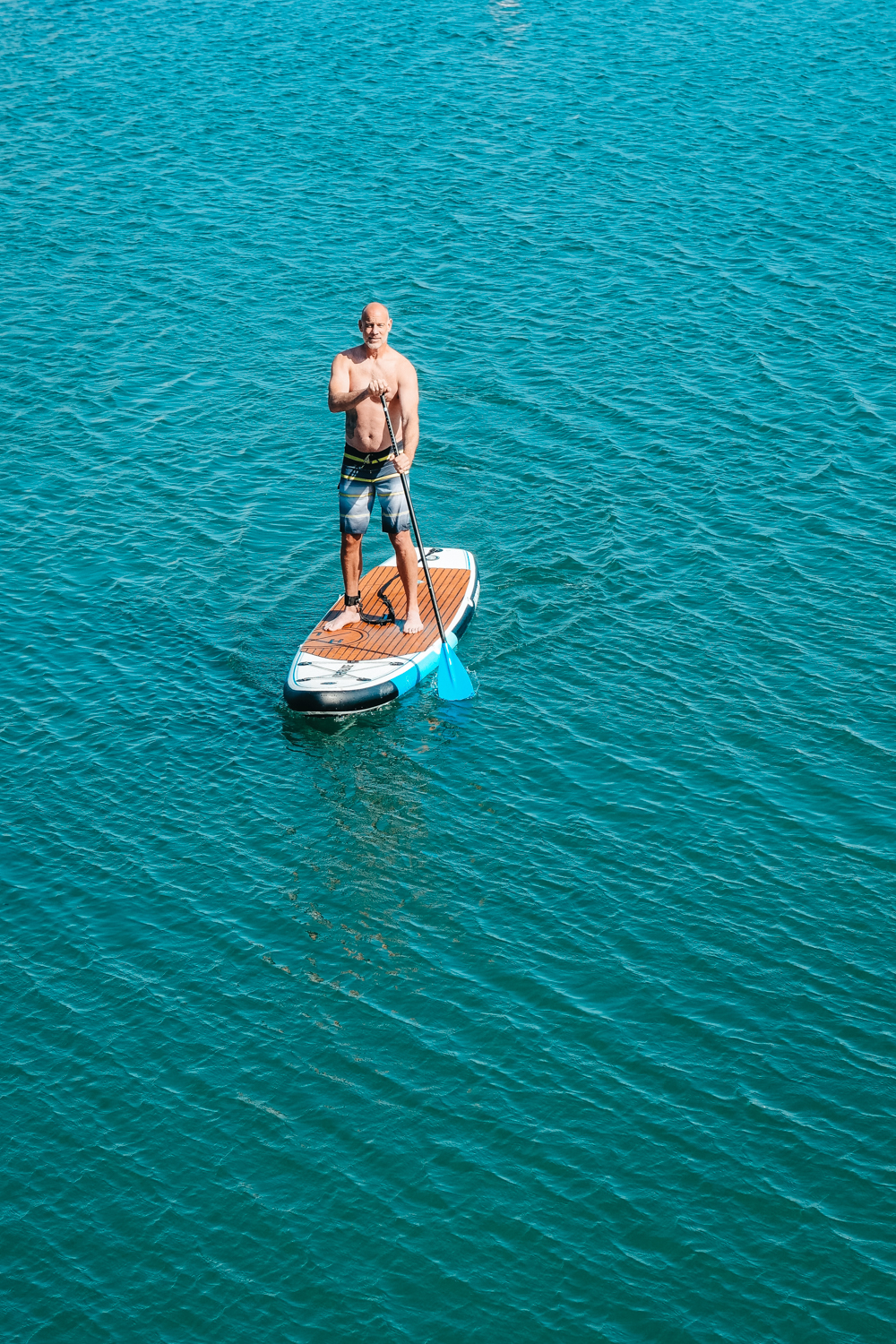Man on paddleboard on blue lake