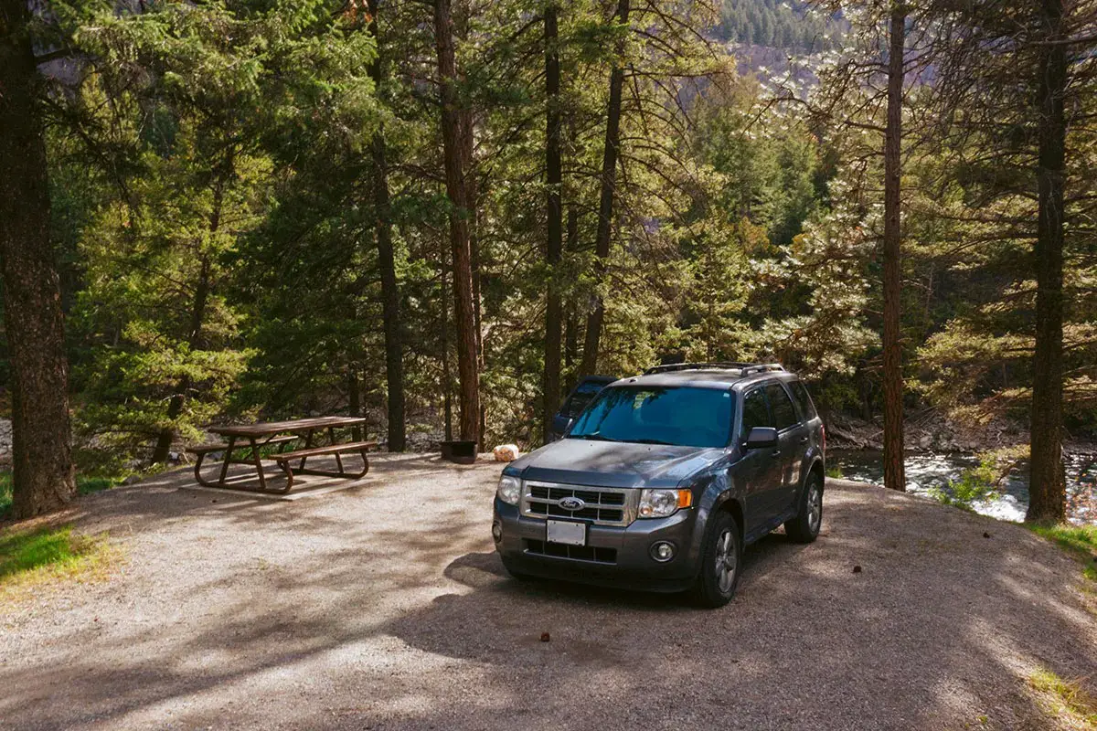 Grey SUV is parked in a campsite at Stemwinder Provincial Park.