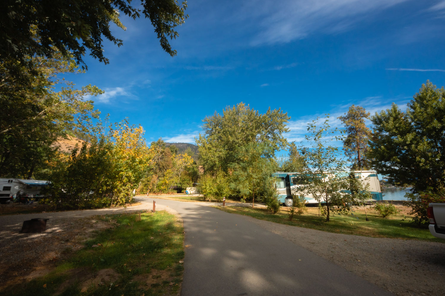 Campsites with an RV at Bear Creek Provincial Park in the Okanagan. Sunny day with a deep blue sky.