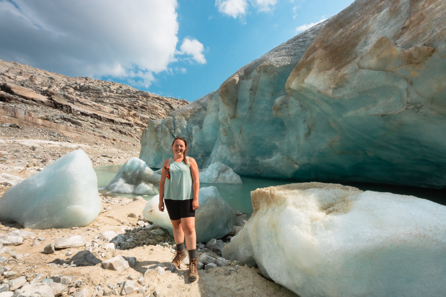 Woman stands in front of a glacial lake at Perley Rock in BC.