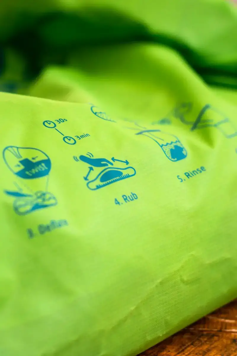 A bright green bag with washing instructions on the side.
