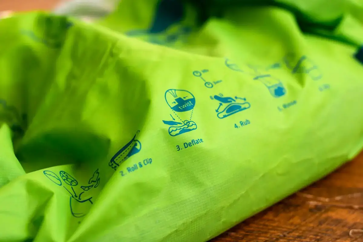 Close up of the side of the green Scrubba laundry bag. Washing instructions are visible on the bag.