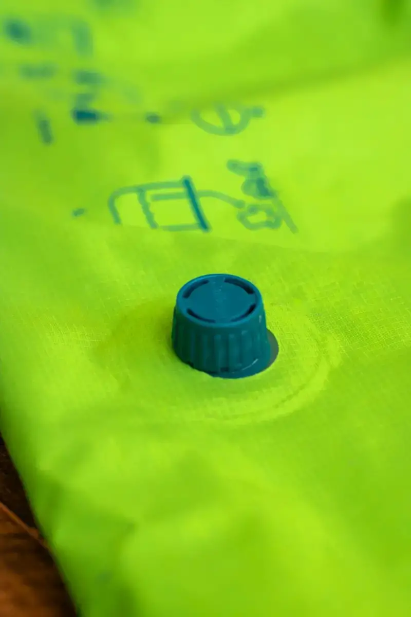 The blue valve that releases air from the Scrubba wash bag. Bright green bag.