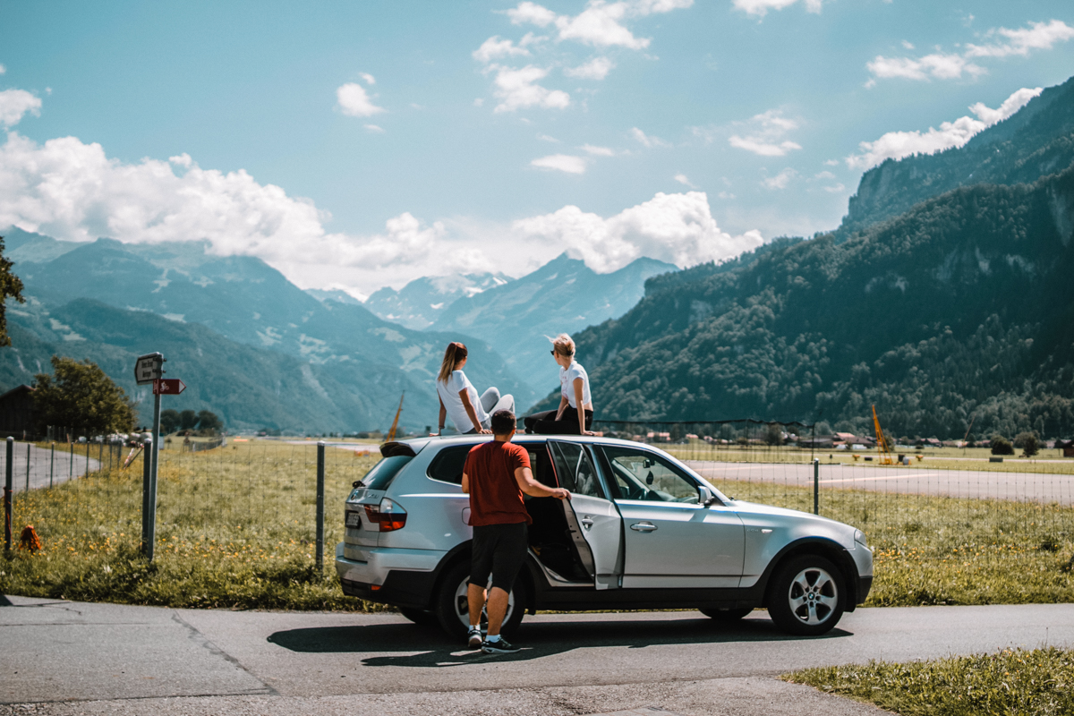 Group of friends relaxing on the side of the road while road tripping.