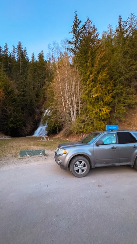 SUV in a rest stop with Ione Falls in the background.