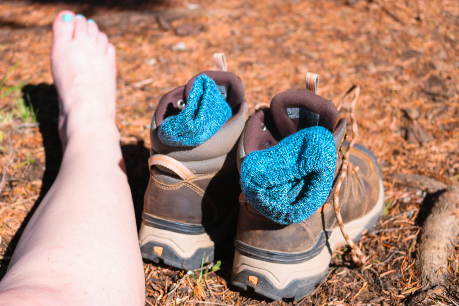 Woman lets her socks air out on a hike.