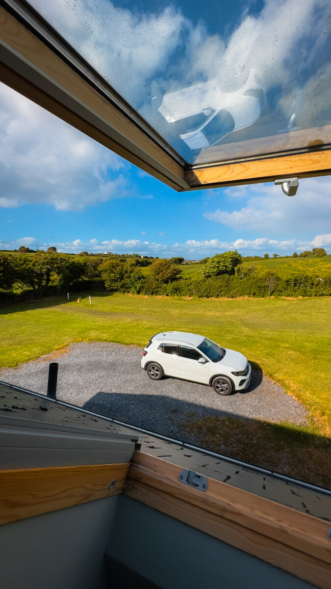 View of a rental car through the upper window of an Airbnb.