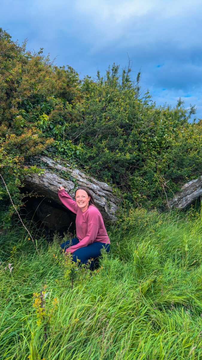 Woman standing in front of a collapsed portal tomb.