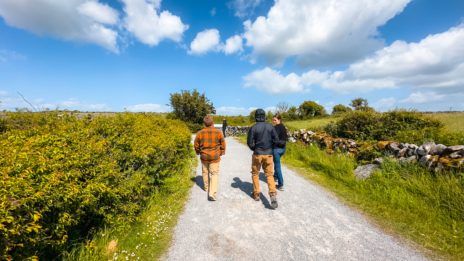 People walking on the gravel path to the Poulnabrone Dolmen.