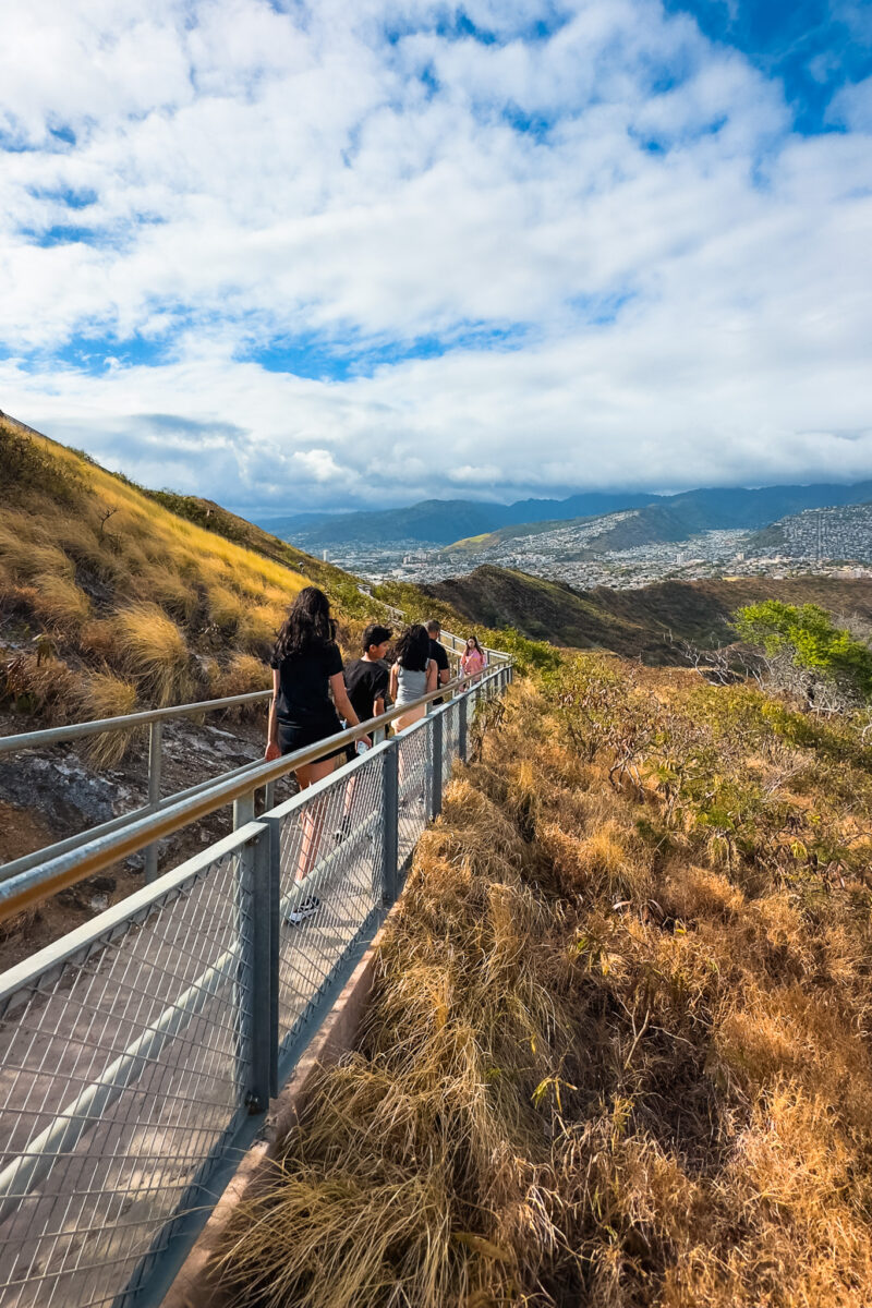 Family walks along a paved trail on the crater wall.