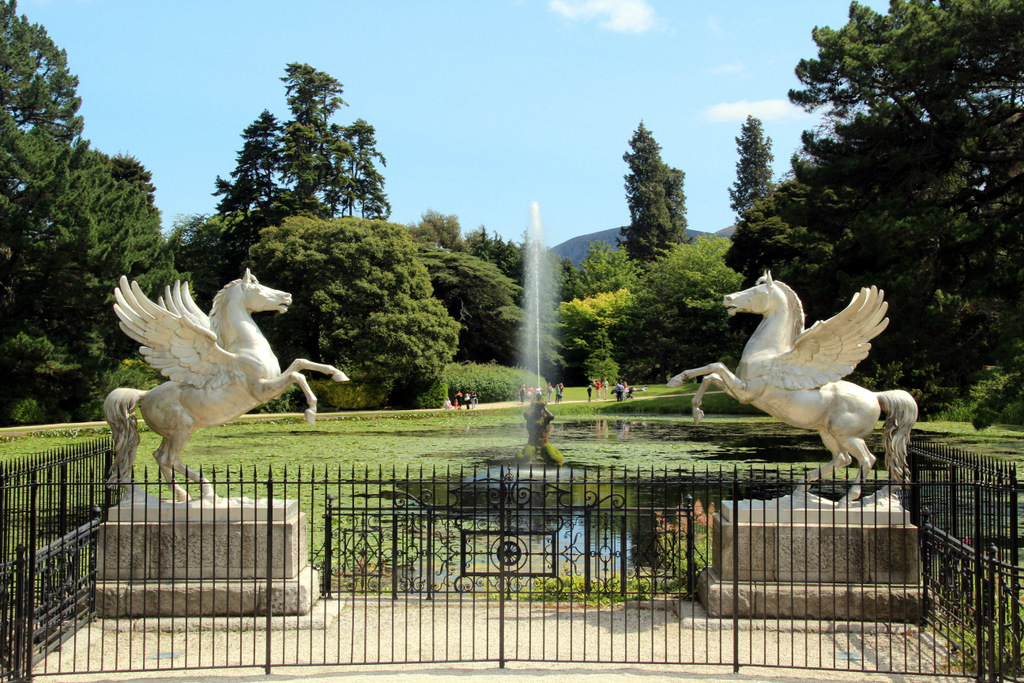 Two unicorn statues in front of a large pond at the Powerscourt Estate.