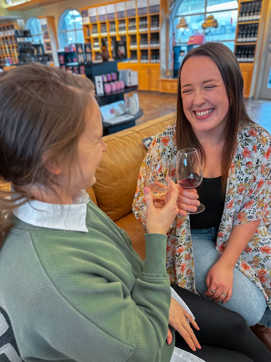 Two women toast wine glasses