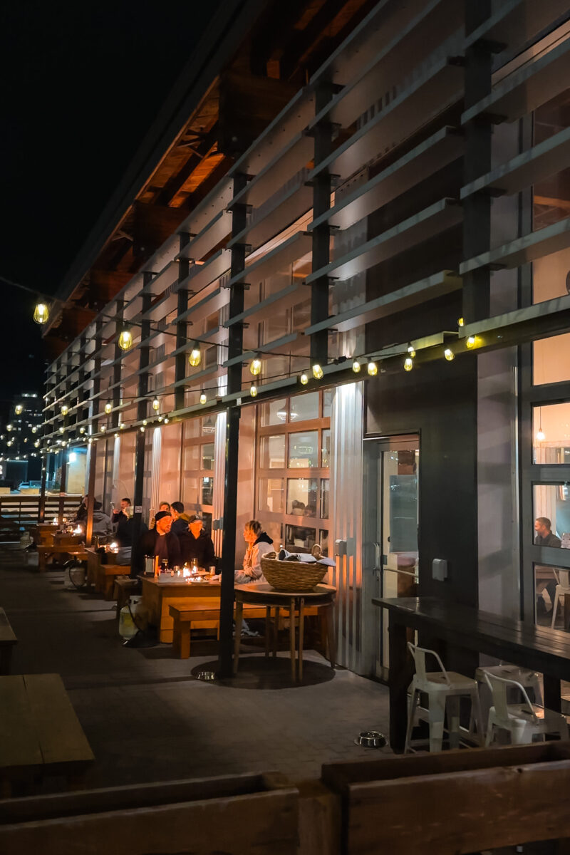 Outdoor dining with a fire pit and fairy lights