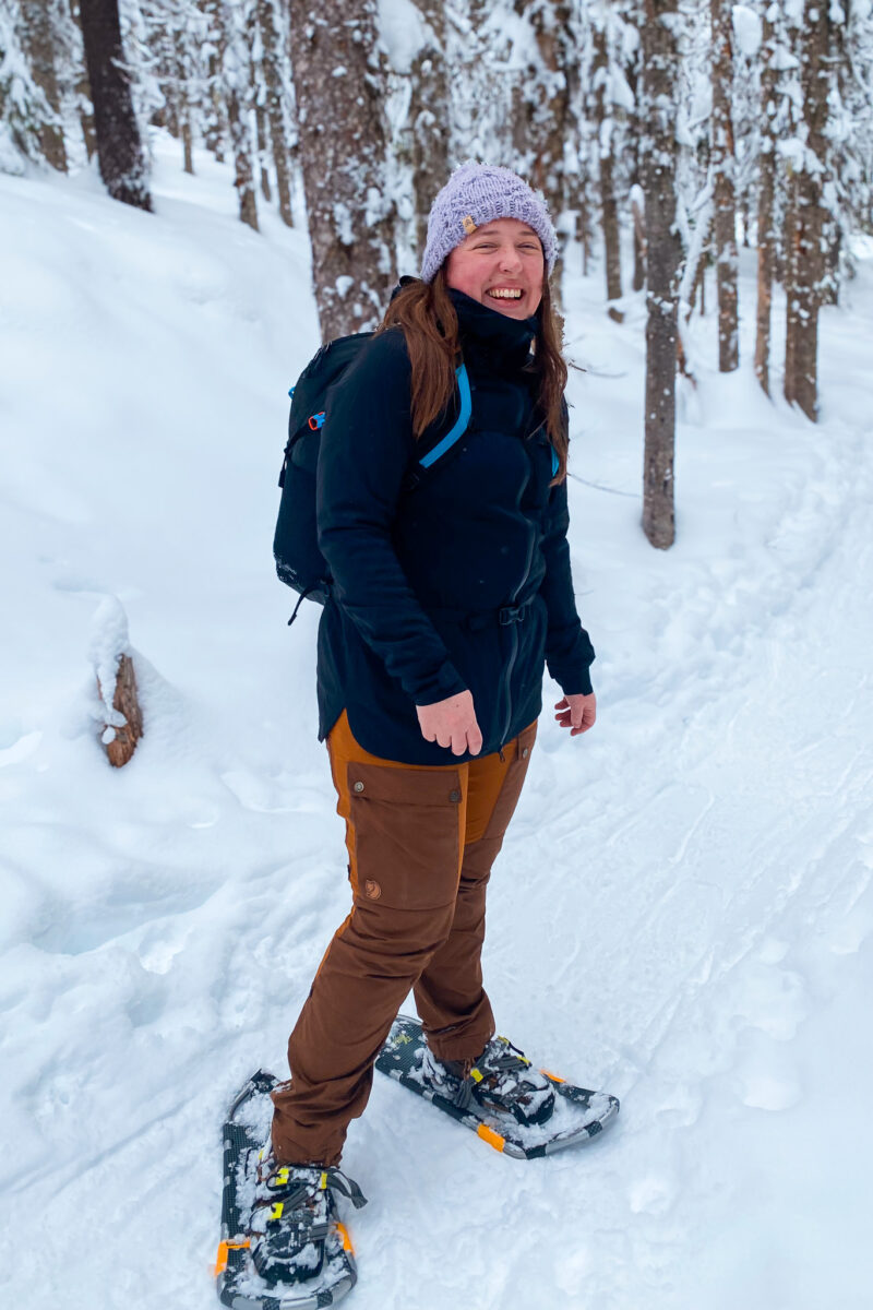 Woman wearing snowshoes in the KUHL Stretch Voyagr jacket.