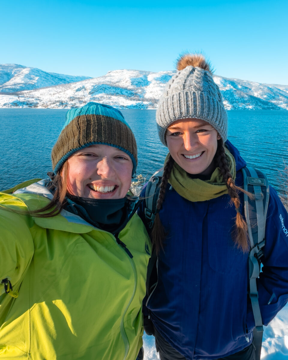 Selfie of two women on a cold, snowy day in front of Okanagan lake.