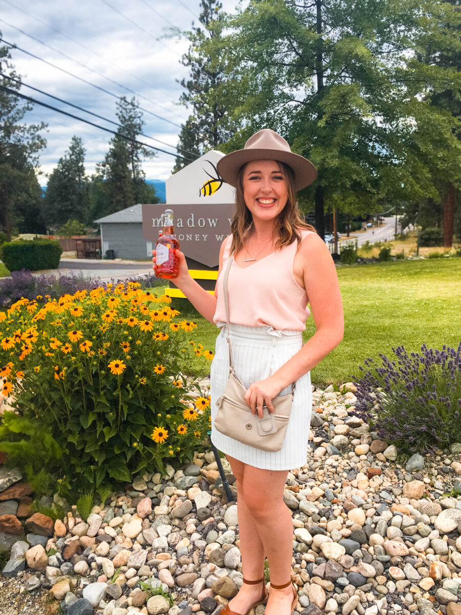 A young woman holding a bottle of mead.