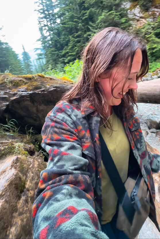 Woman wearing the Flight Sling on a misty waterfall hike