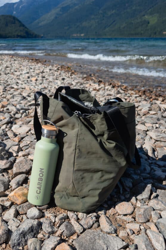 Large ALPAKA tote bag standing upright on rocky beach in the Kootenays