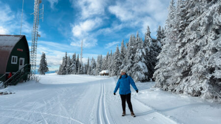 Woman in a blue jacket on top of the mountain in SilverStar in Vernon